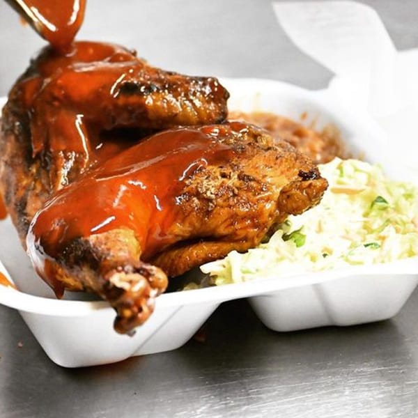 A&R BBQ's grilled chicken, generously coated in BBQ sauce, served with a side of coleslaw.