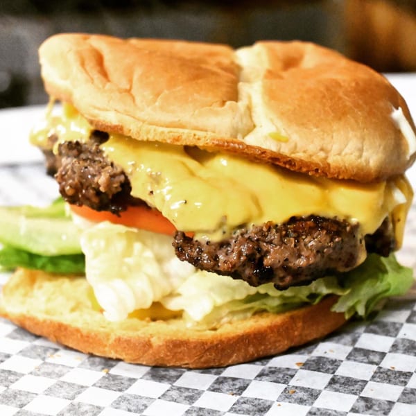A&R BBQ's cheeseburger with melted cheese, lettuce, and tomato on a toasted bun.